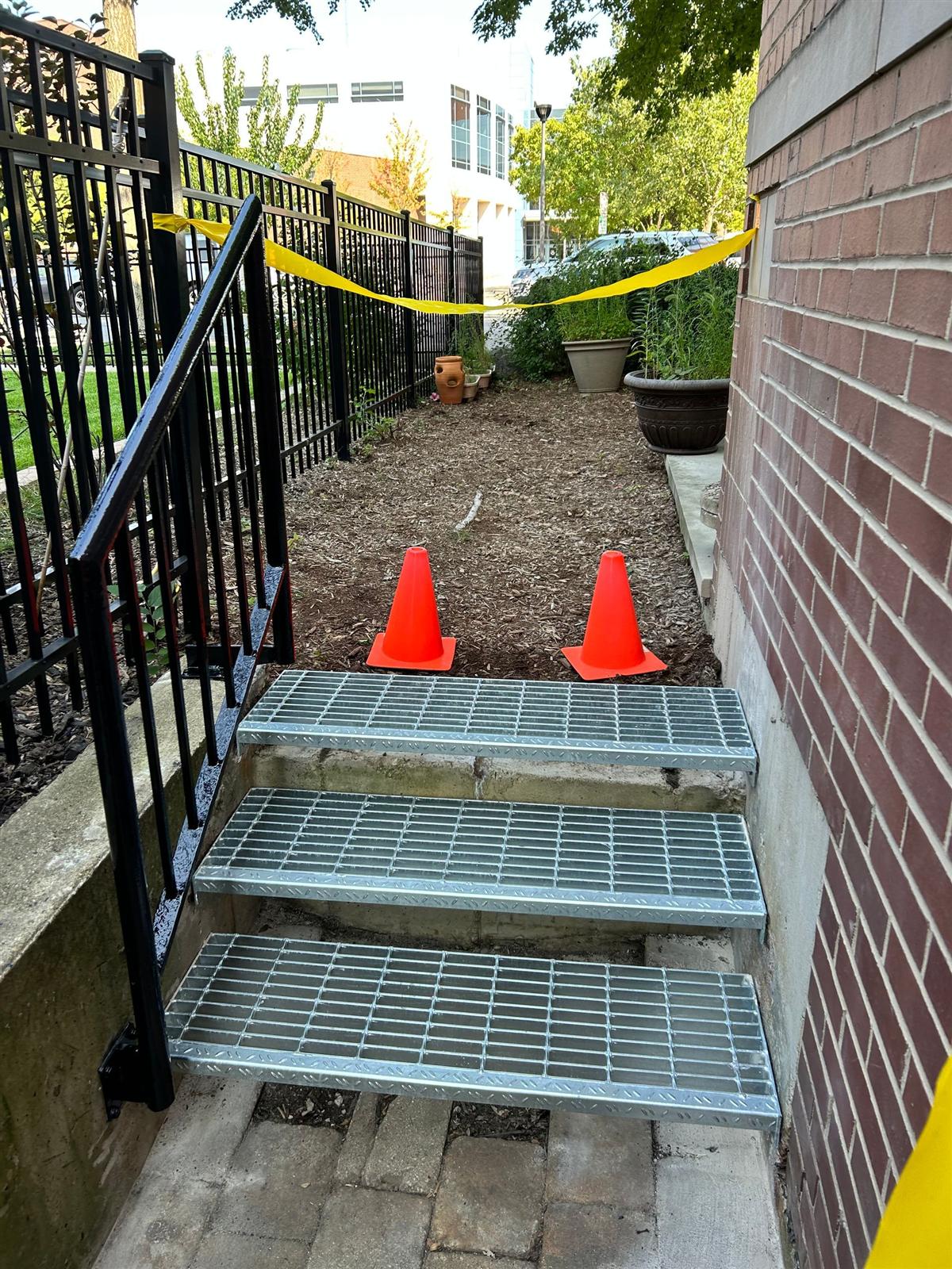 New galvanized bar-grating stair treads fabricated and fitted over concrete steps