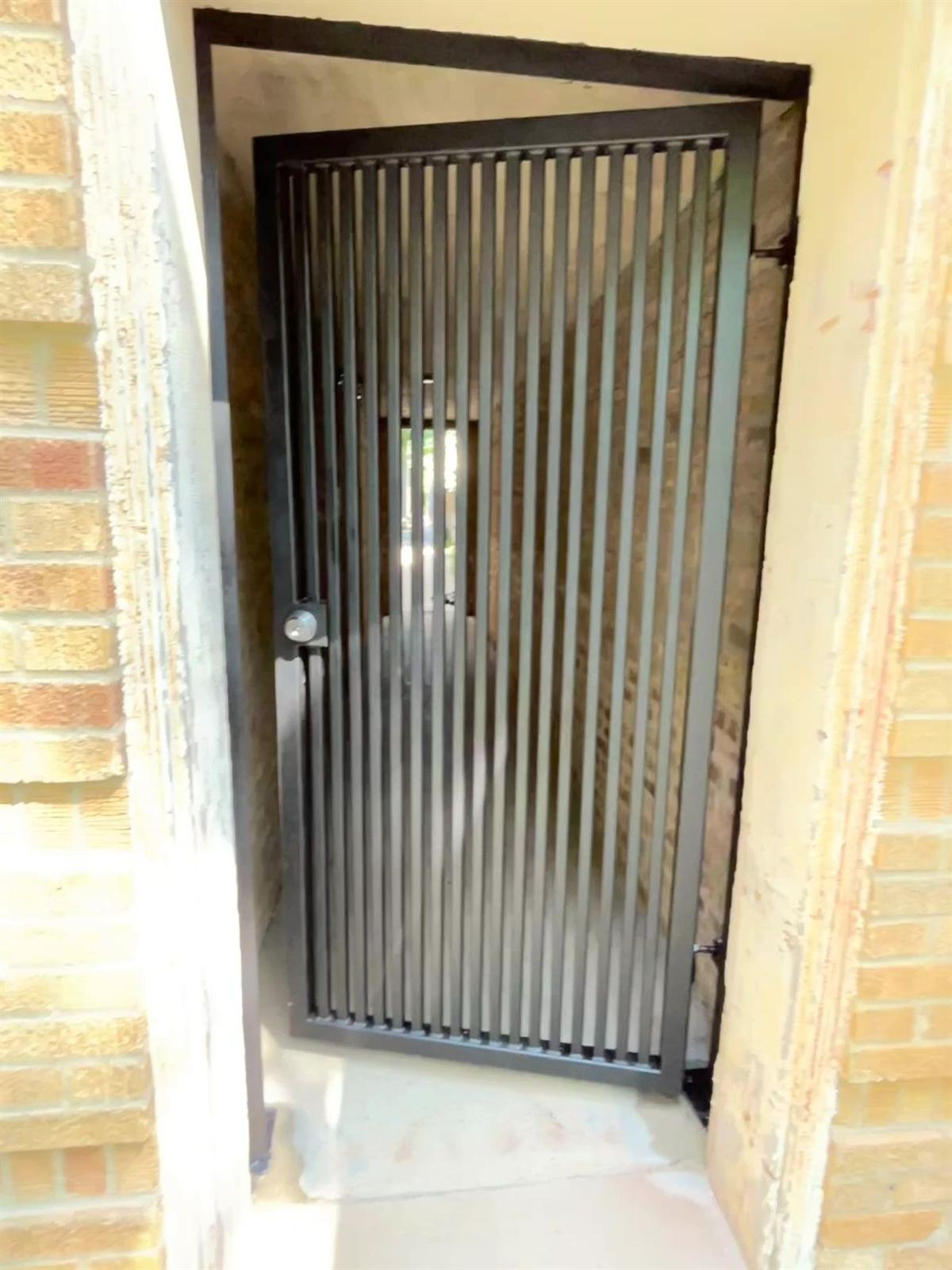 Modern vertical-slat steel security gate installed in a Chicago gangway