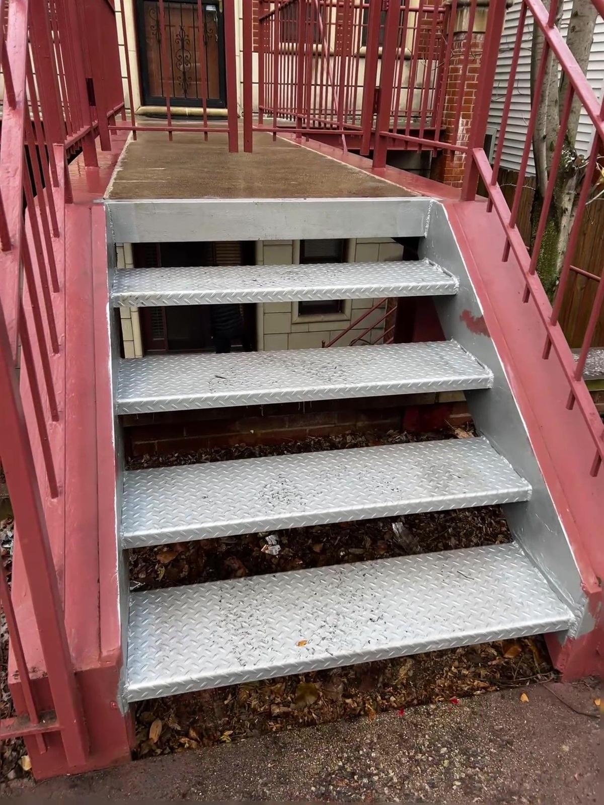 Steel porch repainted red with new galvanized diamond-plate stair treads
