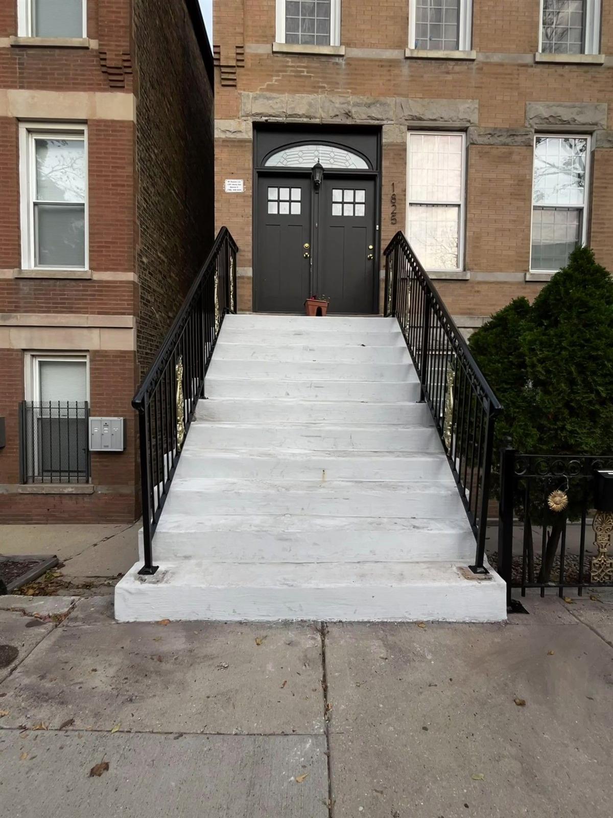 Black steel hand railings fabricated for the front steps of a Chicago two-flat