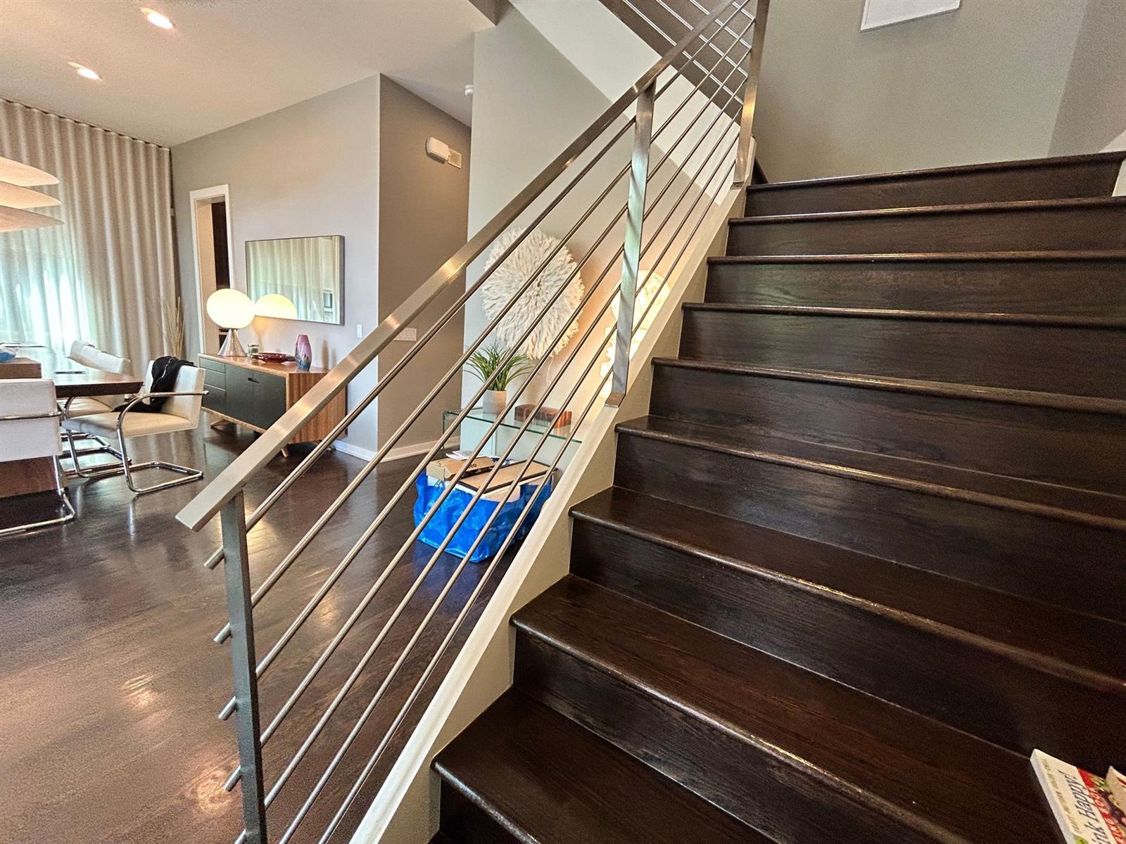 Custom stainless steel flat-bar railing on an interior staircase